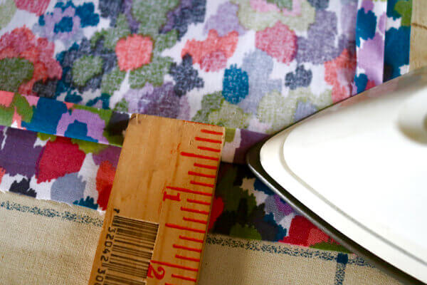 Press down a 1/2" hem. Then, fold over again into another 1/2" hem