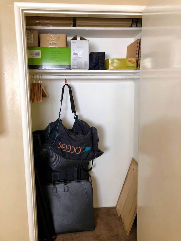 Organized office closet with shelving and hooks keeps equipment and supplies easily accessible
