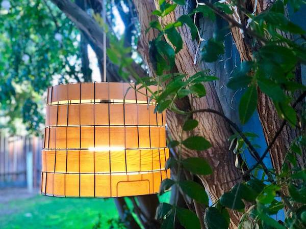 Repurposed metal basket swag light lit up hanging in trees