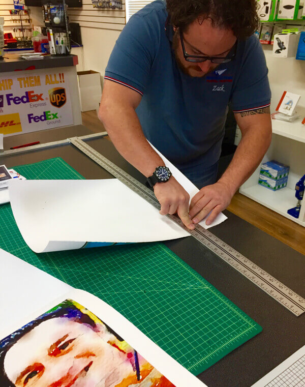 Zack Schwartz, of Manhattan Postal Center, creates a hand torn deckled edge