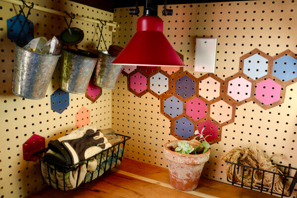 Colorful honeycomb pegboard and custom painted worklight add fun and personality to this do-it-herself space