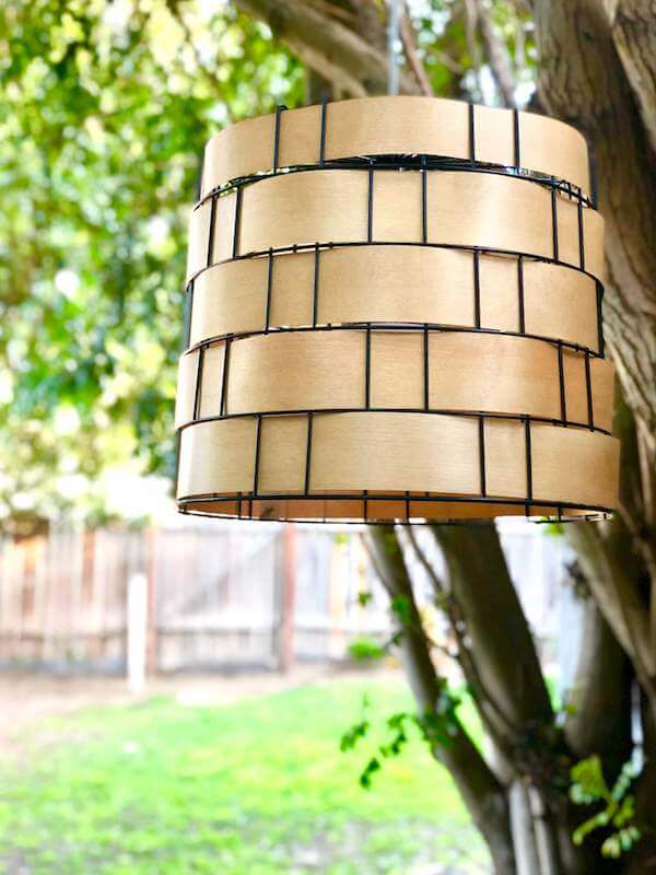 Repurposed metal basket swag light hanging in trees