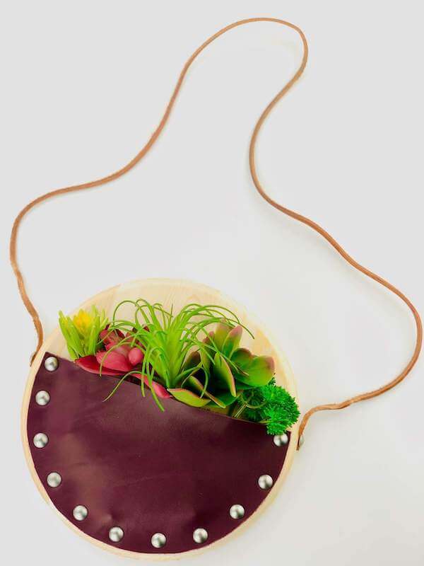 round leather wall pocket filled with faux succulents