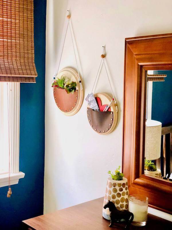 bedroom styled with two hanging round and leather wall pockets